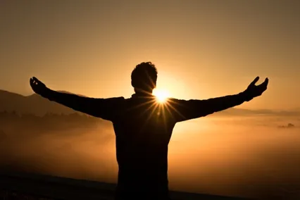 Image of a person with his arms outstretched at sunset to illustrate post