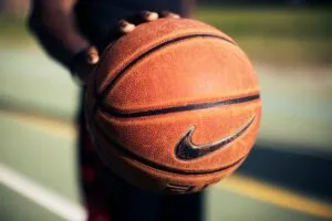Image of hand pushing down on basketball to illustrate post