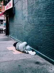 Image of a man lying still on the ground in an alleyway to illustrate post