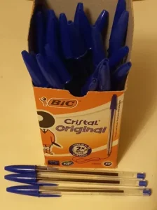 Image of a box containing blue, BIC Cristal original, pens, with three of the pens lying in front of the box, used to illustrate the post.