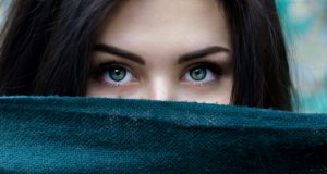 Image of woman looking intensely over a cover hiding the lower part of her face, used to illustrate post.
